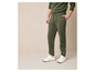 Un homme portant un pantalon de survêtement vert et des baskets blanches.