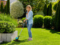 Une femme utilisant une tondeuse à gazon Bosch dans un jardin.