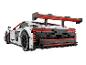 Modèle de voiture de course Audi Sport blanche et rouge avec un grand aileron.