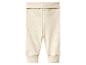 Pantalon bébé côtelé beige avec revers à la taille et aux chevilles.
