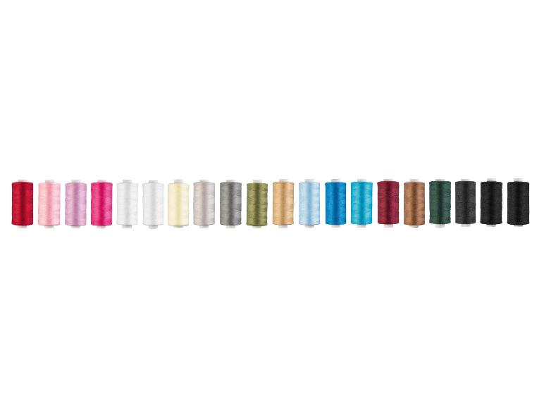 Une rangée de bobines de fil colorées dans des tons de rouge, rose, blanc, jaune, gris, vert, bleu, marron et noir.