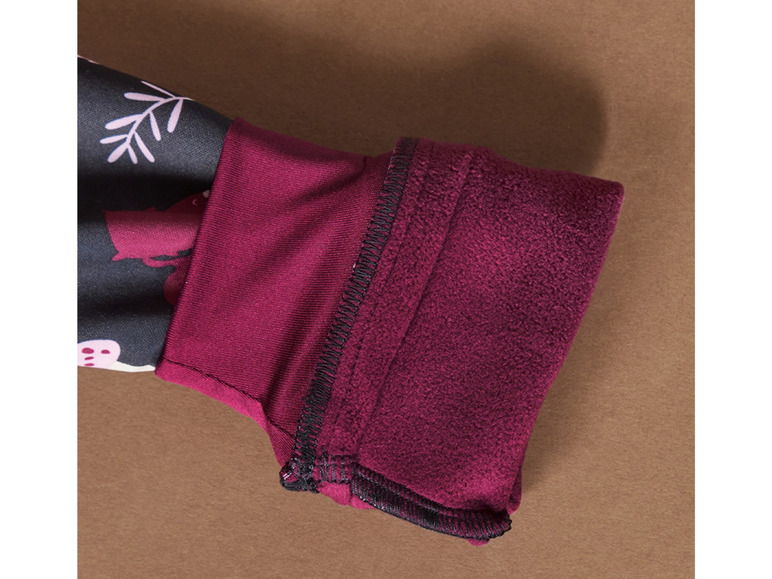 Gros plan sur la manche d'un pull en polaire bordeaux avec un motif.
