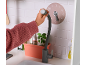Main d'enfant tenant le robinet flexible d'une cuisine en bois pour enfants.