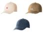Trois casquettes de baseball : beige avec un cœur rouge, marron avec le mot « WORK » et bleue.