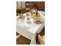 Nappe à motif vert et beige, dressée avec vaisselle et boissons en extérieur.