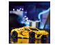 Voiture de sport LEGO Technic jaune sur une surface réfléchissante avec des lumières bleues floues en arrière-plan.