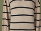 Pull beige à rayures noires.
