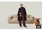 Femme en tailleur-pantalon violet et manteau noir devant un canapé.