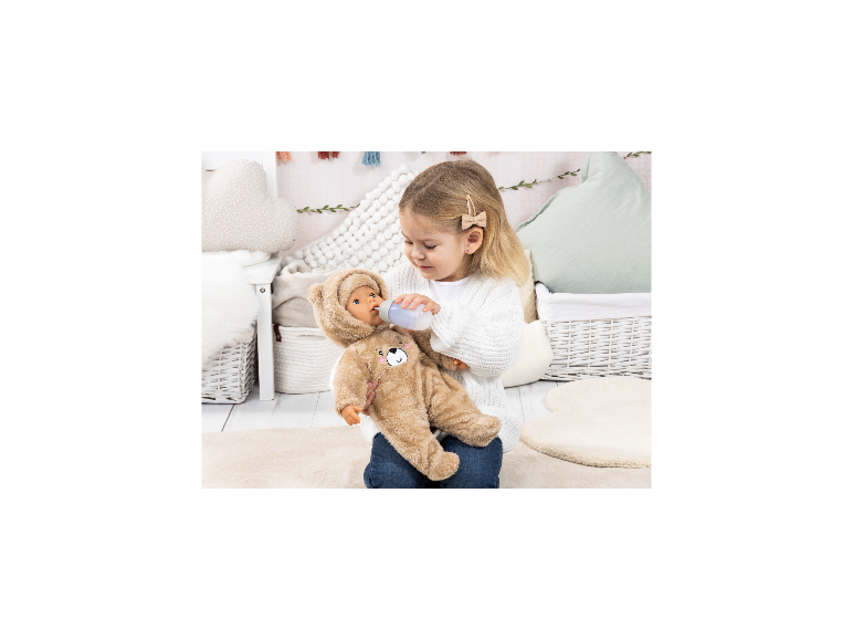 Poupée BAYER DESIGN Piccolina Magic Tears en costume d'ours nourrie au biberon par un enfant