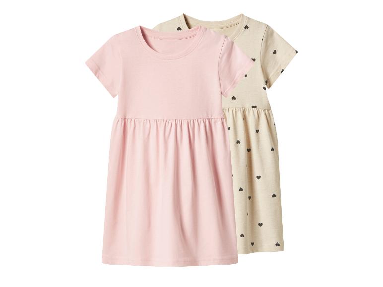 Robes d'enfants roses et beiges à manches courtes, la beige avec motif cœurs.