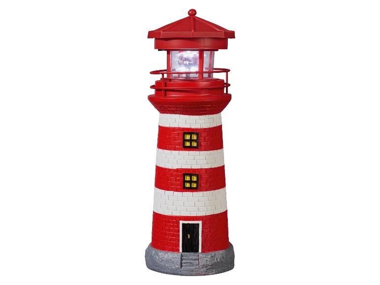 Lampe décorative en forme de phare à rayures rouges et blanches avec un sommet lumineux.