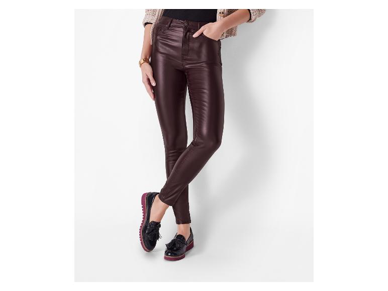 Femme portant un jean skinny brun foncé et des mocassins noirs à pompons.