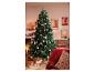 Sapin de Noël décoré d'ornements roses et argentés, près d'une cheminée avec des bougies.