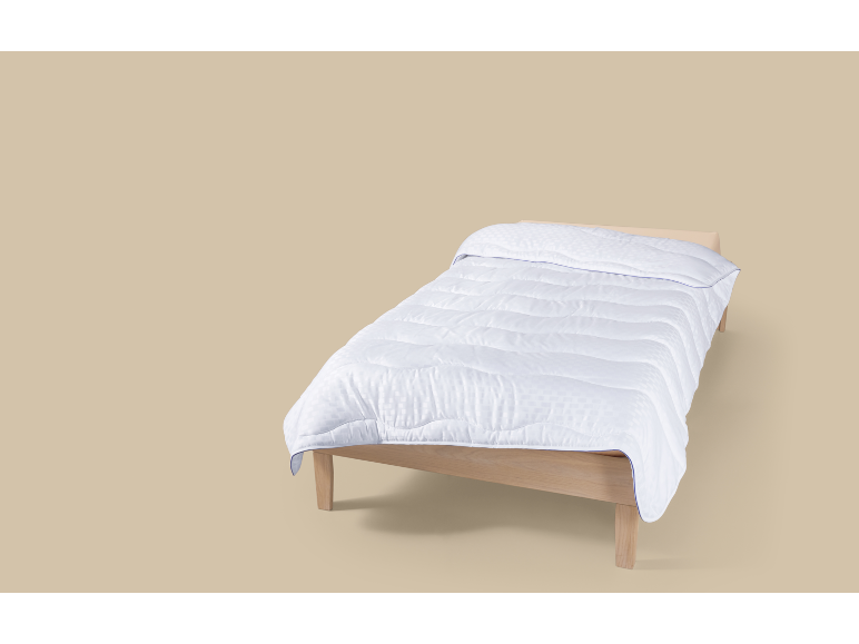 Couette blanche sur un lit en bois.
