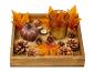 Plateau en bois avec bougies, pommes de pin et feuilles d'automne.