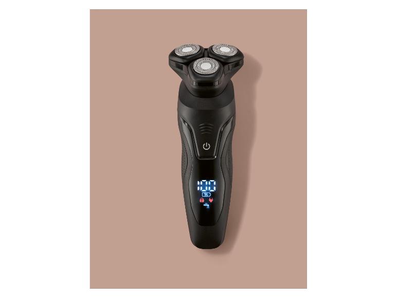 Rasoir électrique rotatif noir avec affichage numérique sur fond marron clair.