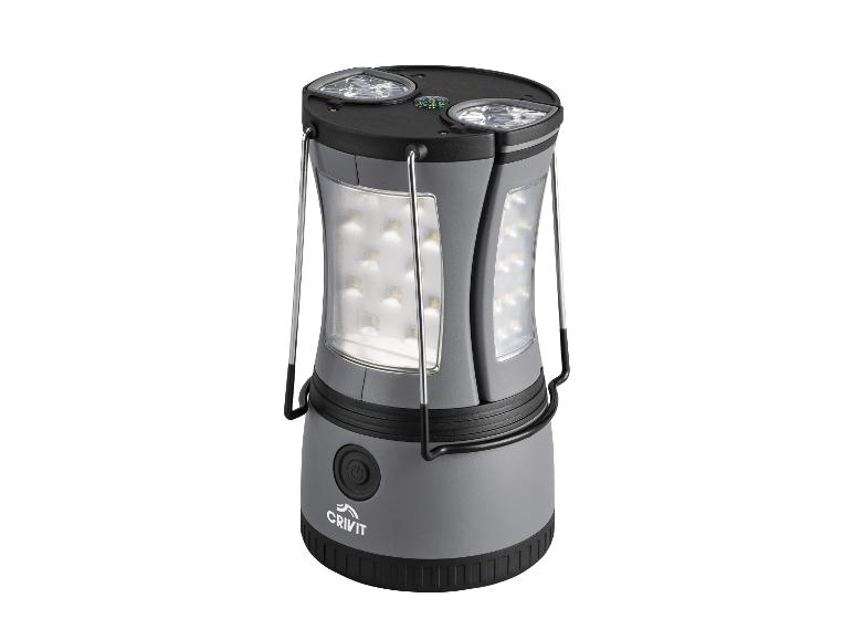 Lampe de camping LED grise avec boussole intégrée et poignées de transport.