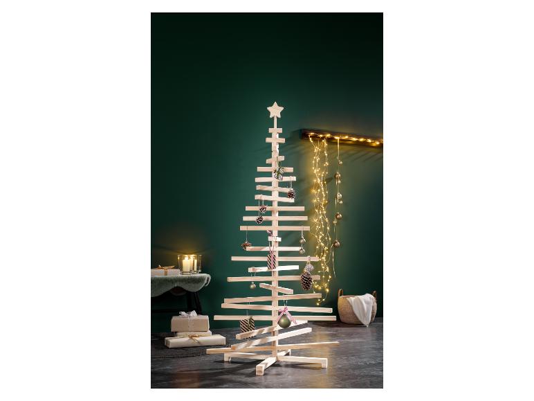 Un sapin de Noël moderne en bois décoré d'ornements et de lumières dans une pièce festive.