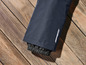 La jambe d'un pantalon bleu foncé avec un ourlet élastique.