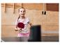 Fille jouant au tennis de table, tenant une raquette rouge.