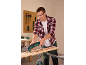 Homme utilisant un outil multifonction pour racler du bois, portant des lunettes de sécurité et des bouchons d'oreille.