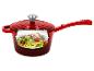 Casserole rouge avec une vue en coupe montrant des nouilles de courgettes aux tomates et pignons de pin.