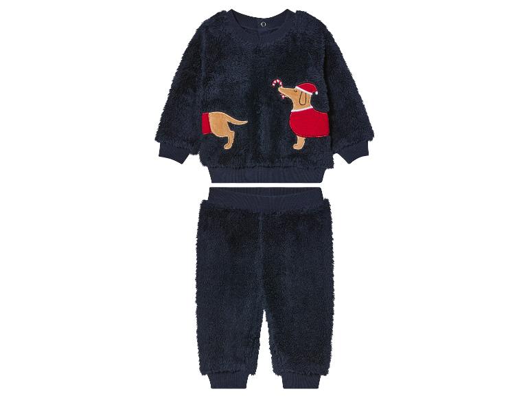 Un ensemble pull et pantalon bleu marine de Noël avec un motif de teckel brodé.