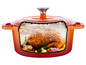 Une cocotte en fonte orange avec un poulet rôti à l'intérieur.