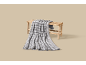 Couverture à carreaux gris posée sur un banc en bois