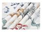 Tissu blanc avec motifs de feuilles colorées, plié