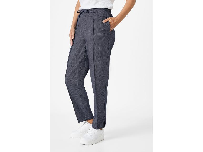Pantalon élégant bleu marine et baskets blanches.