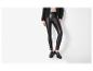 Femme en legging noir en similicuir, veste noire et mocassins noirs.