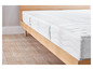 Un matelas blanc sur un cadre de lit en bois.