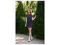 Une femme portant une robe bleu foncé, des chaussettes blanches et des chaussures noires.
