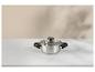 Casserole en acier inoxydable avec couvercle en verre sur une surface en marbre blanc.