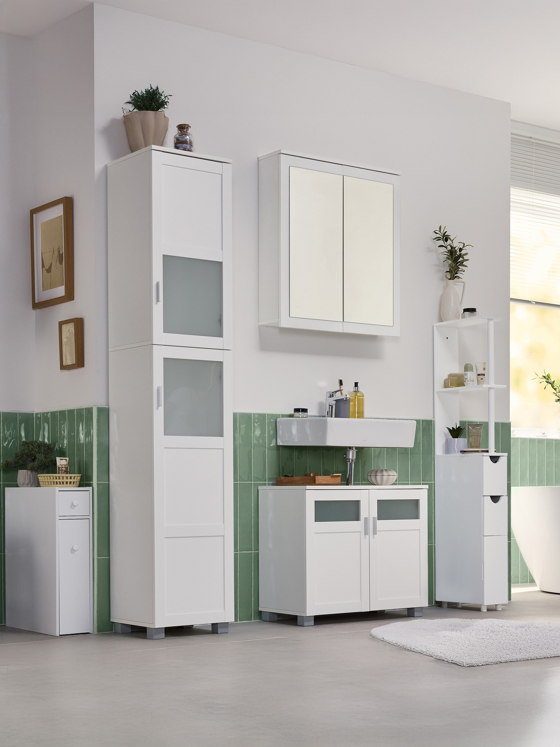 Salle de bain avec des armoires blanches, un lavabo et des carreaux muraux verts.