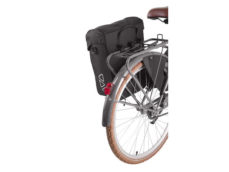 Sacoches de vélo noires sur porte-bagages arrière avec feu arrière rouge et roue.