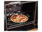 Pizza fraîchement préparée dans un plat de cuisson vert, placée sur une grille de four ouverte.