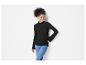 Une femme porte un pull noir à manches longues et un jean bleu.