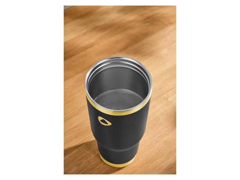 Mug thermique noir avec des détails jaunes sur une surface en bois.