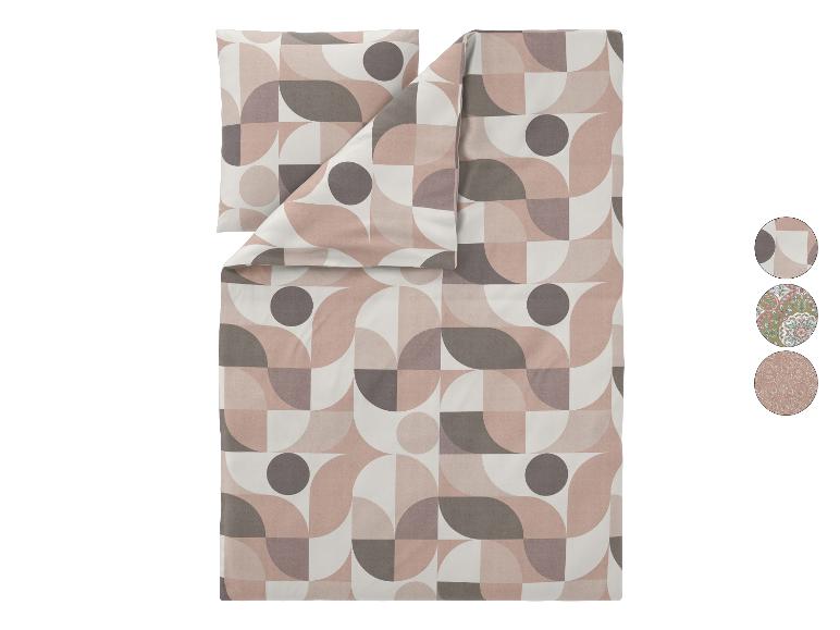Parure de lit et taie d'oreiller à motif géométrique dans les tons rose, gris et blanc.