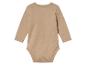 Un body bébé à manches longues de couleur beige.