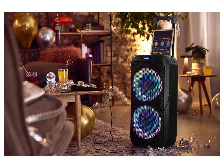 Enceinte karaoké avec microphone et tablette, entourée de décorations de fête et de ballons.