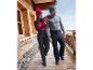 Un couple marchant sur une passerelle en bois en vêtements d'hiver, y compris des pantalons et des bonnets.