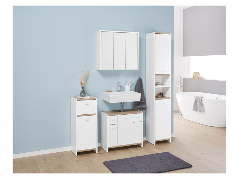 Meubles de salle de bain blancs avec un lavabo, une armoire à miroir et deux armoires hautes.