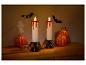 Décoration d'Halloween avec deux bougies dégoulinantes de sang, des citrouilles, des chauves-souris et un fantôme.