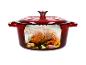 Cocotte en fonte rouge avec un poulet rôti à l'intérieur.