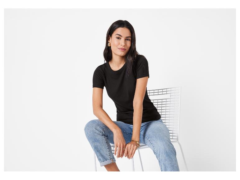 Modèle portant un t-shirt noir et un jean.
