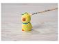 Figurine de poussin de Pâques jaune avec un pinceau la peignant en jaune.