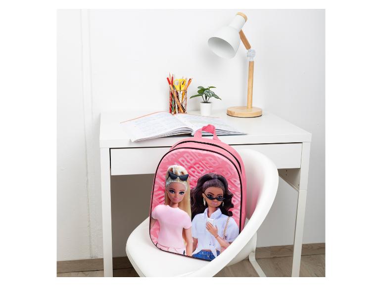 Un sac à dos rose avec un motif Barbie sur une chaise blanche.